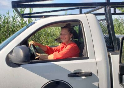 woman in white work truck with golden retriever dog